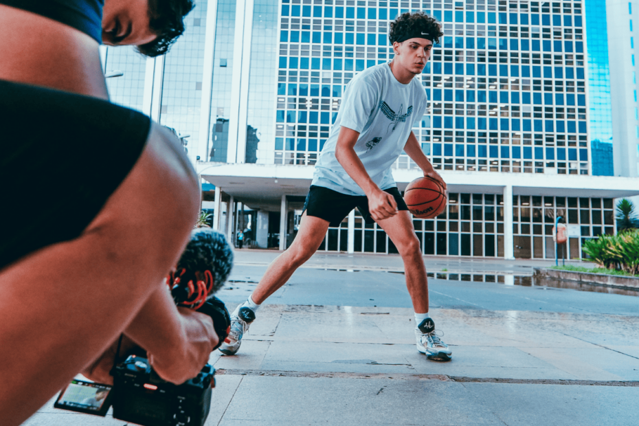 Cinegrafista gravando garoto jogando basquete