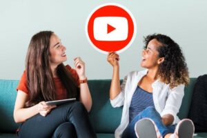 Mulheres sentadas no sofá segurando um ícone do YouTube